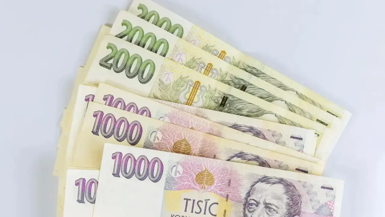 Kupka banknotów 1000 i 2000 koron czeskich, waluta w Czechach, leży na białym tle.