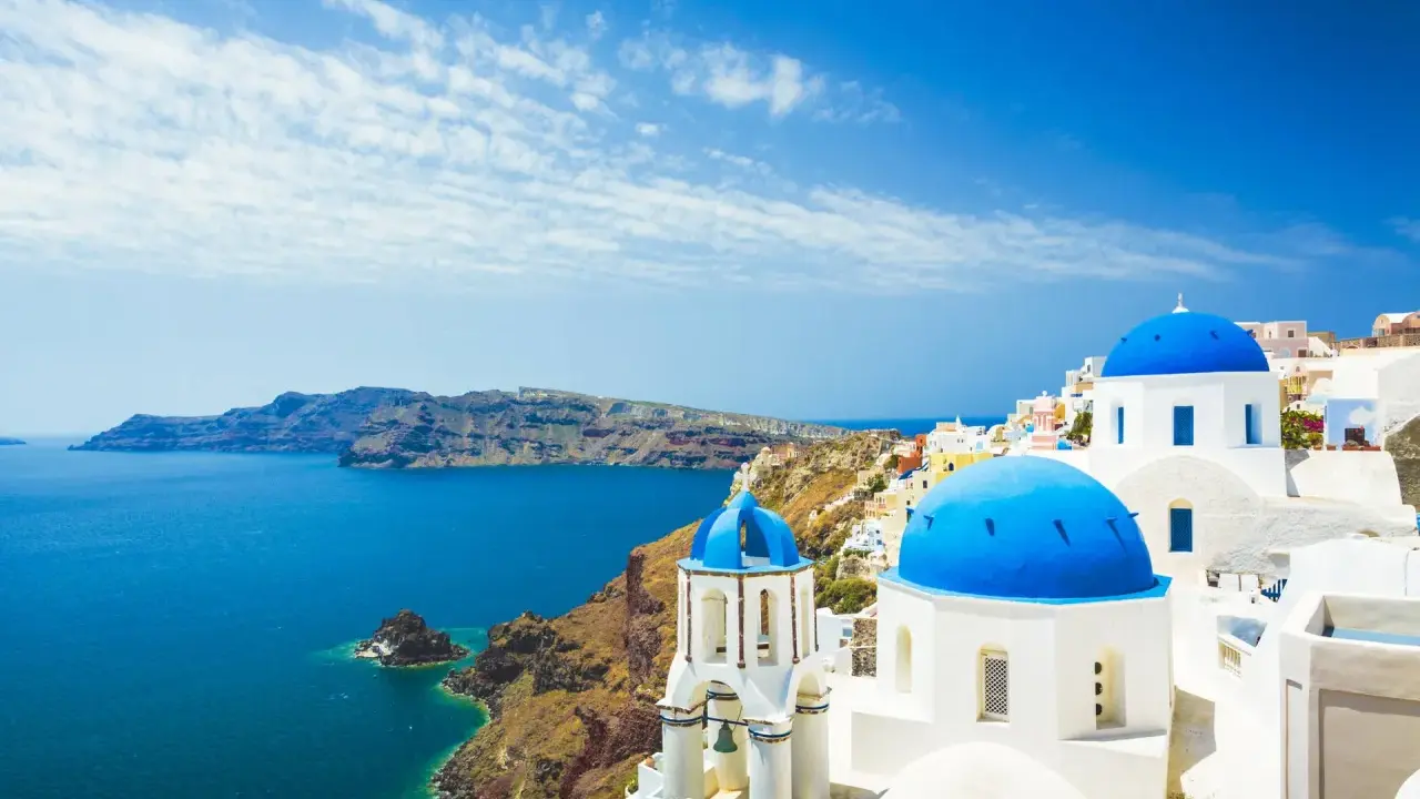 Santorini, Grecja. Białe domy z niebieskimi kopułami nad morzem. Sprawdź ceny wakacji!