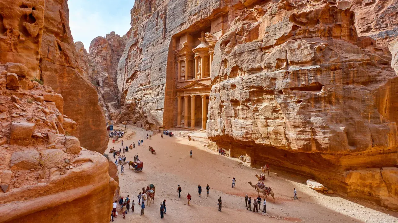 Skaliste wąwozy Petry, Jordania. Wspaniałe widoki, idealne na jordania loty. Turyści i wielbłądy w drodze do Skarbca.