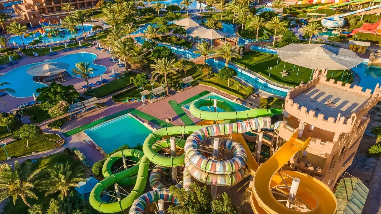 Wodne szaleństwo w Akassia Swiss Resort! Kolorowe zjeżdżalnie, baseny i palmy tworzą idealne miejsce na wakacje.
