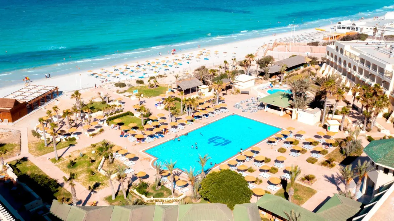 Widok z lotu ptaka na hotel Vincci Dar Midoun. Basen, plaża, palmy i leżaki. Wiele pozytywnych vincci dar midoun opinie potwierdza ten widok.