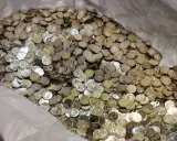 Ogromna ilość monet, prawdopodobnie bułgarska waluta, wypełnia worek.