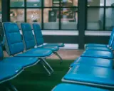 Puste, niebieskie krzesła na lotnisku. Zastanawiasz się, ile wcześnie być na lotnisku, by zająć najlepsze miejsce?