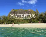 Plaża na Mauritiusie z turkusową wodą, piaszczystym brzegiem i skalistym masywem w tle.