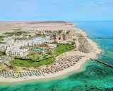 Albatros Palace Port Ghalib: rozległy kompleks hotelowy z basenami, palmami i plażą pełną leżaków, otoczony pustynnym krajobrazem i turkusowym morzem.