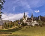 Zamek Peles w Rumunii na tle gór i jesiennego krajobrazu.