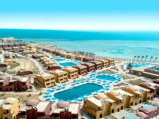 Widok z lotu ptaka na kompleks hotelowy Pickalbatros w Marsa Alam. Wiele budynków z kopułami, baseny i plaża nad Morzem Czerwonym.