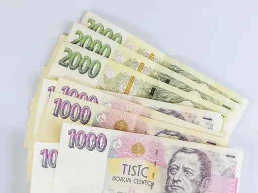 Kupka banknotów 1000 i 2000 koron czeskich, waluta w Czechach, leży na białym tle.