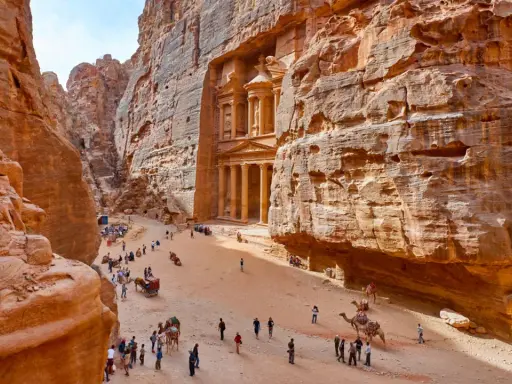 Skaliste wąwozy Petry, Jordania. Wspaniałe widoki, idealne na jordania loty. Turyści i wielbłądy w drodze do Skarbca.