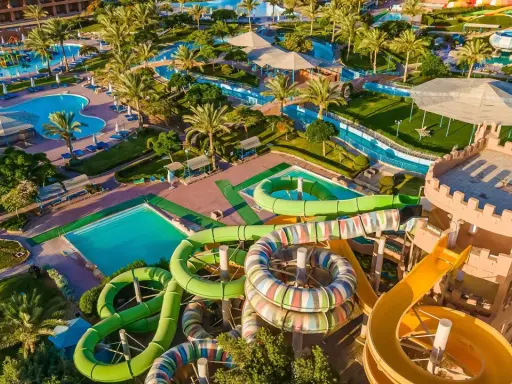 Wodne szaleństwo w Akassia Swiss Resort! Kolorowe zjeżdżalnie, baseny i palmy tworzą idealne miejsce na wakacje.