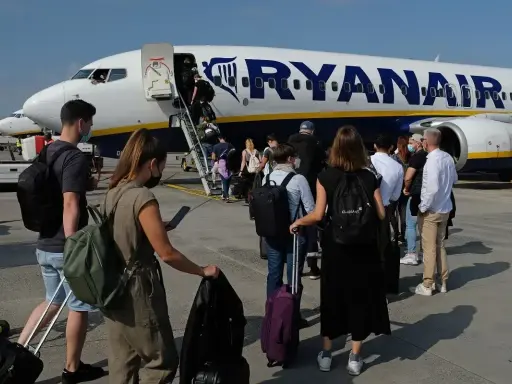 Pasażerowie wchodzą po schodkach do samolotu Ryanair.