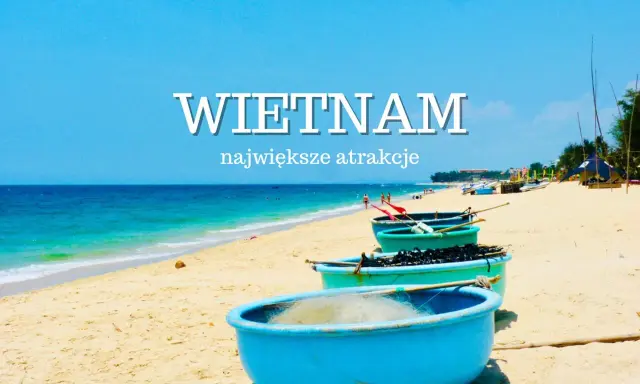 Niebieskie łodzie na piaszczystej plaży Wietnamu z turkusowym morzem w tle.