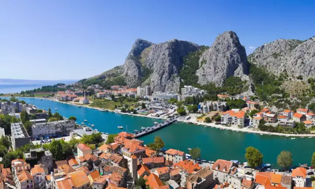Widok na miasto Omis w Chorwacji z rzeką Cetina i górami w tle.