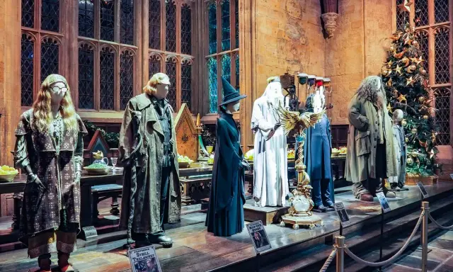 Manekiny postaci z Harry'ego Pottera w strojach, w tym Hagrid i Dumbledore, obok choinki.