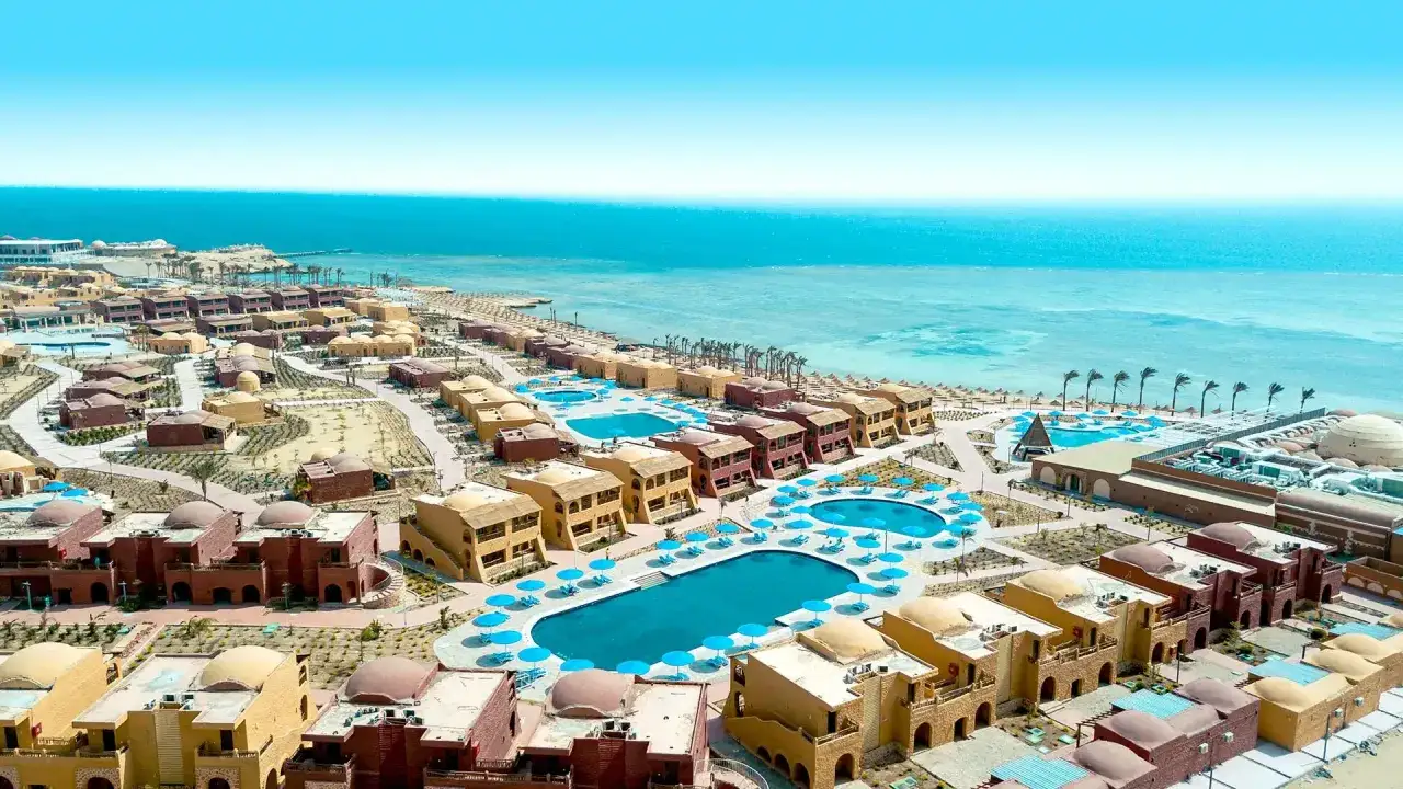 Widok z lotu ptaka na kompleks hotelowy Pickalbatros Marsa Alam z basenami i budynkami w stylu orientalnym, w tle turkusowe morze.