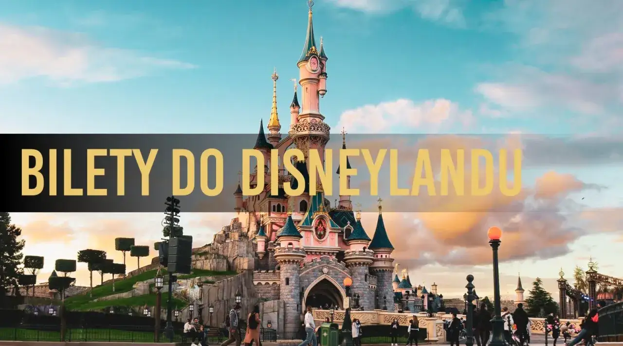 Zamek w Disneyland Paris na tle zachodzącego słońca. Napis 