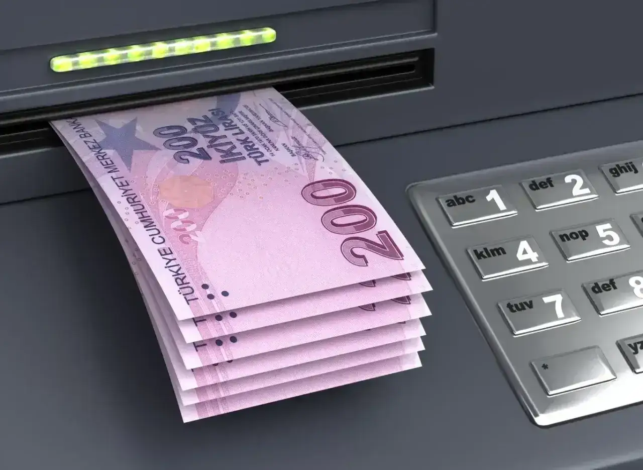 Banknoty 200 lir tureckich wychodzące z bankomatu. W Turcji płaci się lirami.